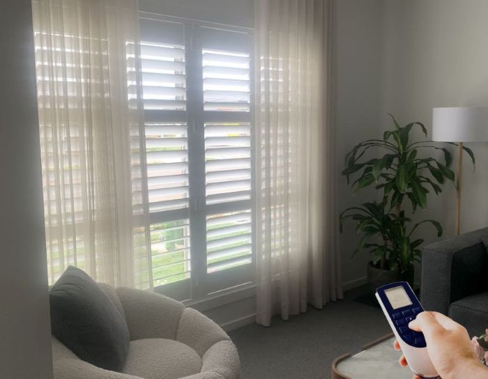 Homeowner operating the plantation shutters remotely.