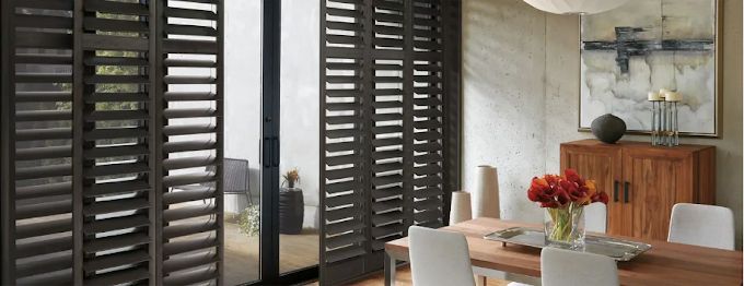 Sliding plantation shutters covering a large glass door